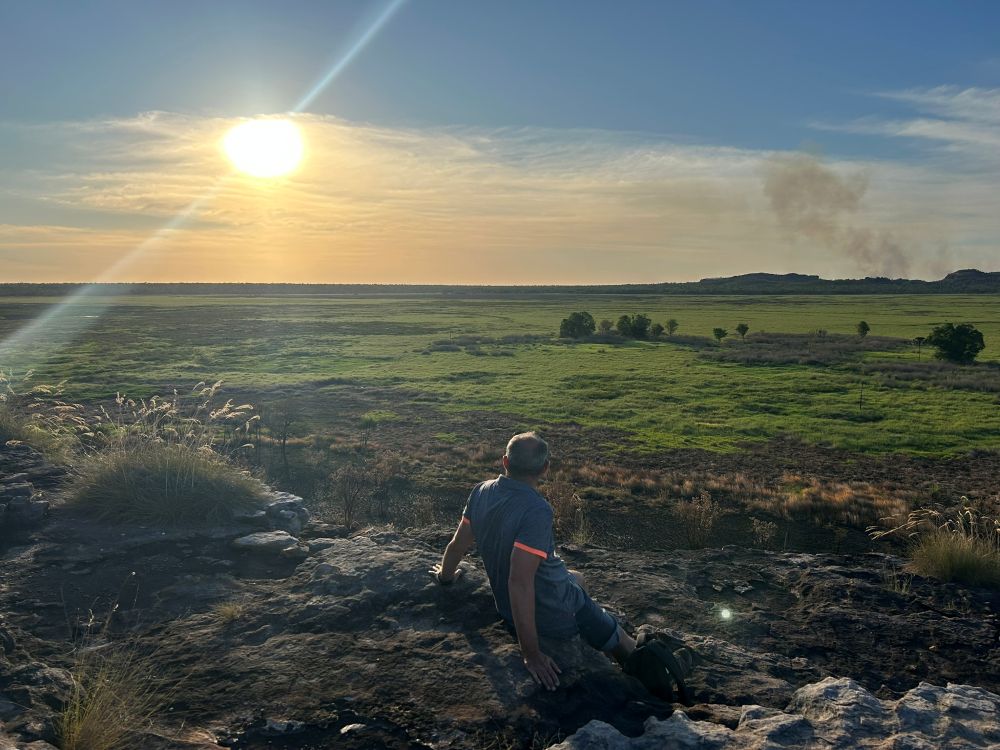 Man kijkt uit over de laagvlakte bij zonsondergang vanaf Ubirr in Kakadu