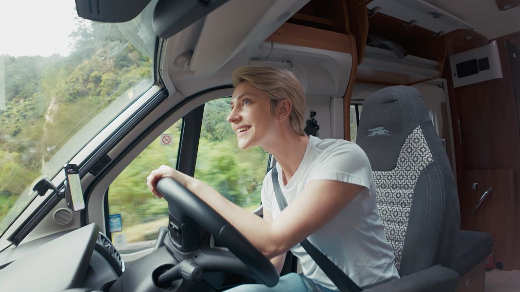 Vrouw is aan het rijden door Nieuw-Zeeland in de Britz Odyssey camper