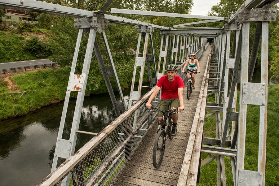 Stel is aan het mountainbiken over de Hauraki Rail Trail in de Karangahake Gorge