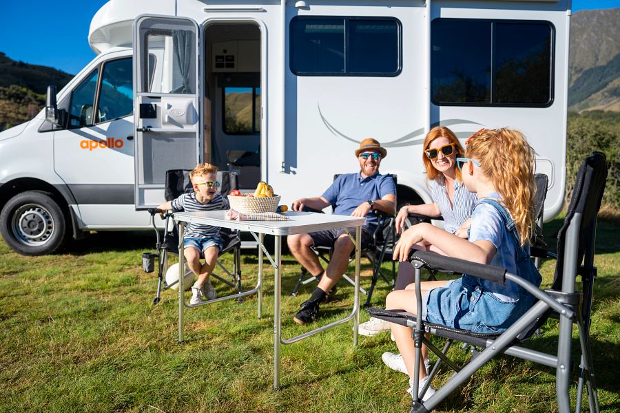 Gezin met jonge kinderen zit in campingset buiten bij Apollo Euro Quest