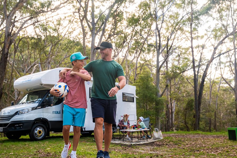 Vader gaat voetballen met zoon, moeder zit met dochter buiten voor de Maui Beach camper