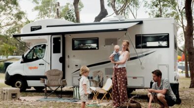Moeder met kind op de arm voor de Apollo Euro Deluxe camper op de camping