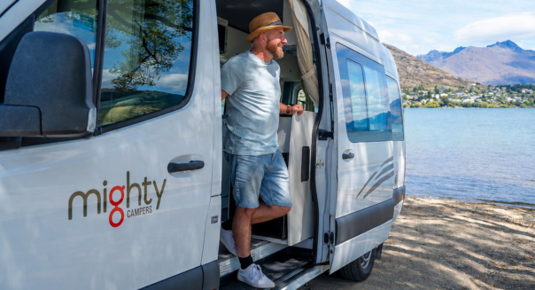 Man staat in de deuropening van de Mighty Deuce met uitzicht op Queenstown