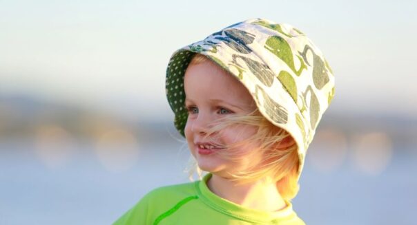 Jong kind met zonnehoedje op: bescherm kinderen tegen de zon