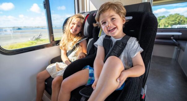 Twee kinderen zitten in kinderautostoelen in de camper