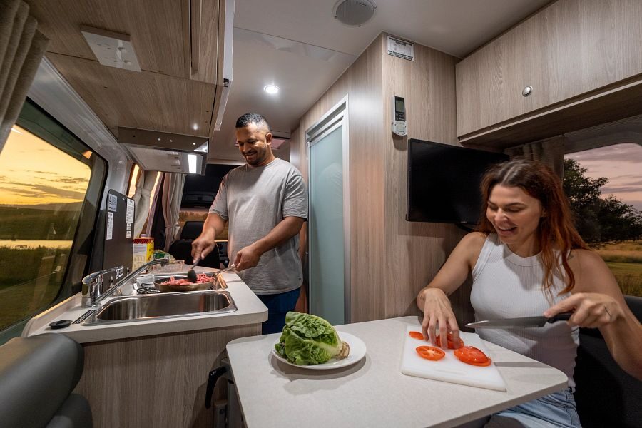 Man en vrouw zijn aan het koken in de Apollo Euro Tourer camper