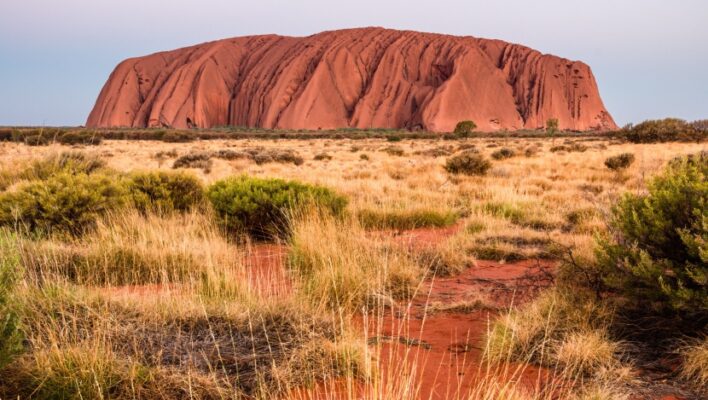 Zicht op Uluru Ayers Rock in het red Centre vanaf de gravelweg