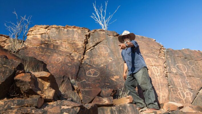 Aboriginal wijst naar voren bij rotstekeningen in Flinders Ranges in South Australia