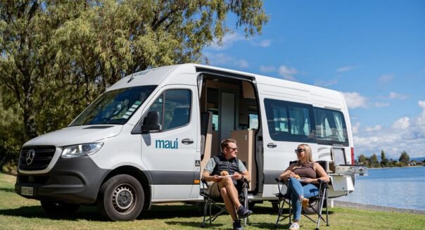 Koppel zit in campingstoelen voor de Maui Ultima met de zijdeur open