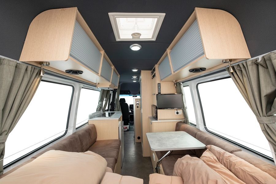 Interieur van de Maui Ultima camper gezien vanuit de zithoek en het bed achterin