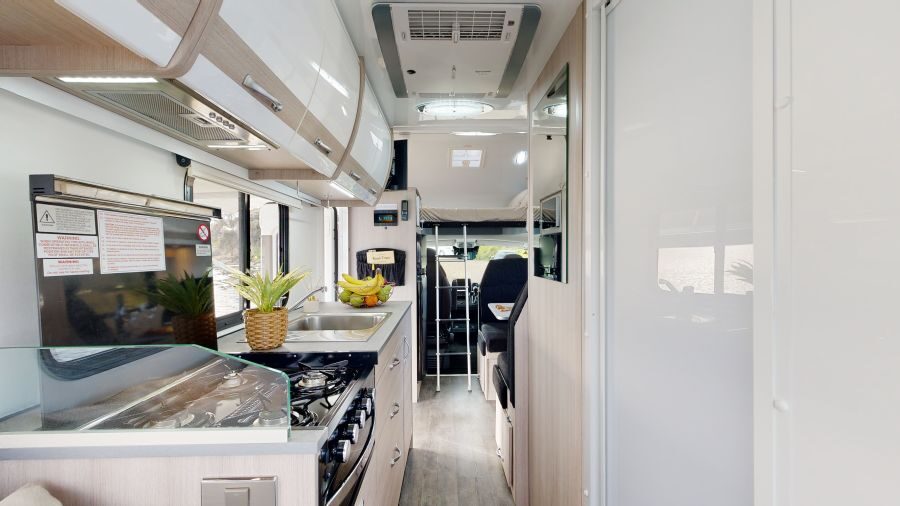 Keuken in de Cruisin' 4 Berth Deluxe met zicht op bed in alkoof