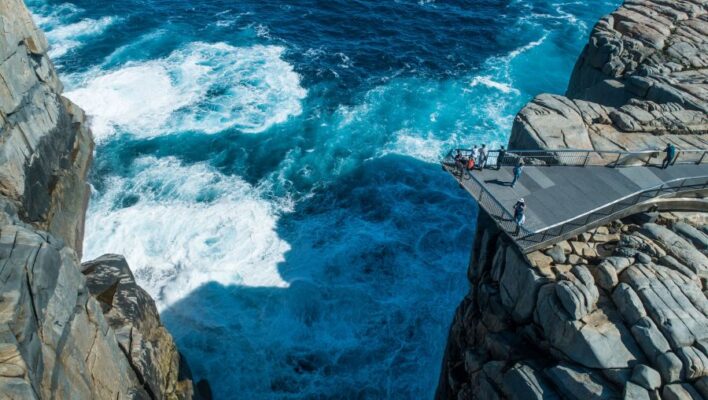 Groot gat tussen de rotsen met platform waar mensen staan te kijken in Torndirrup national park