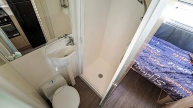 Badkamer met toilet en wastafel met deur open in de Mighty Big Six camper