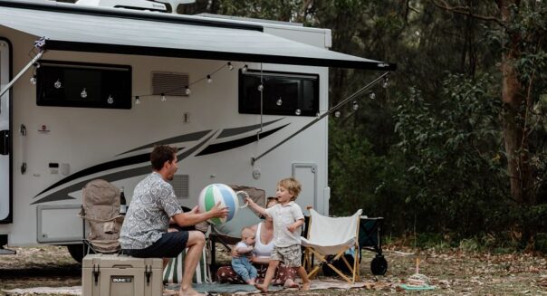 Vader speelt buiten met kind met een opblaasbal voor de camper Apollo Euro Deluxe