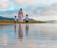 Moeder loopt met jonge kinderen over het strand in Australië