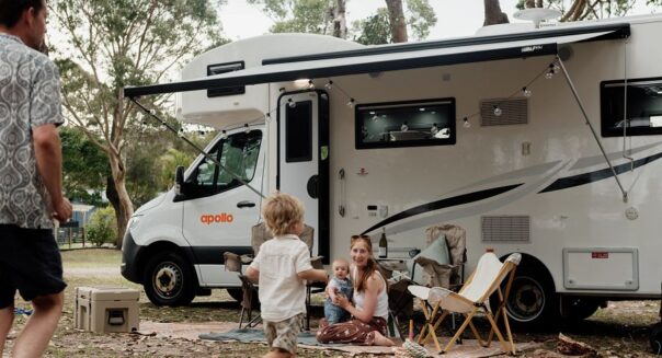 Vader loopt met kind af op moeder met kind die voor de Apollo Euro Camper op de grond zitten