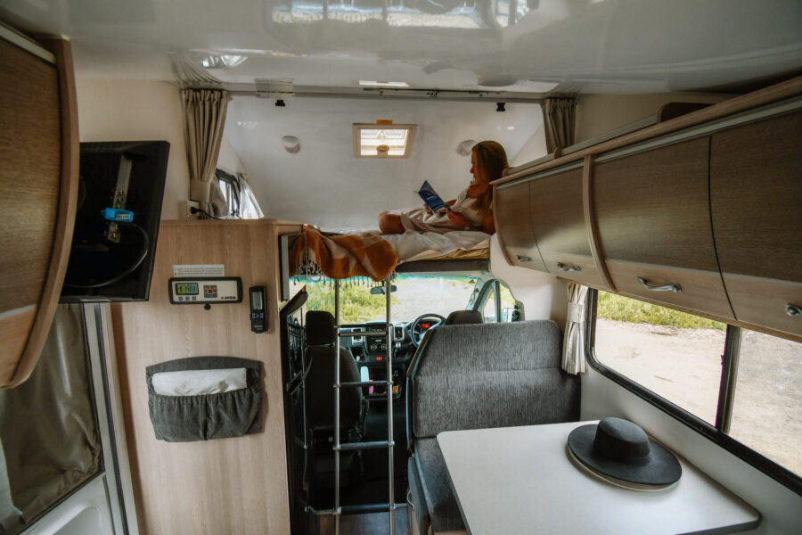 Vrouw ligt in het bed in de alkoof van de Cruisin' Adventurer