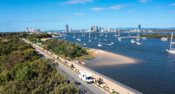 Mighty Double Up camper rijdt in dronebeeld langs de skyline van de Gold Coast