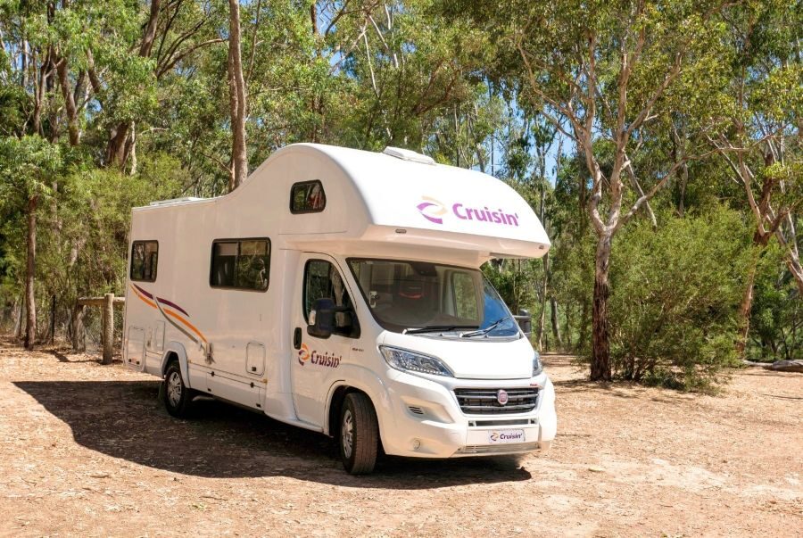 Cruisin' 4 Berth Adventurer camper staat geparkeerd voor bomenrij