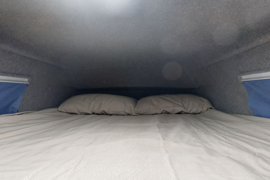 Het bed bovenin de Go Cheap 4 Berth Hitop is opgemaakt