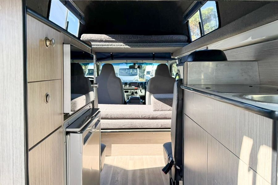 Zicht op de koelkast, magnetron en het interieur van de Go Cheap 4 Berth Hitop