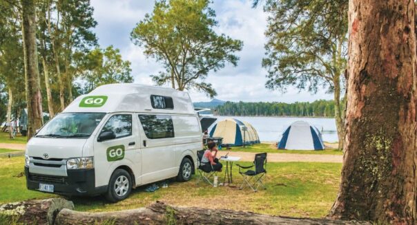 Twee mensen zitten buiten bij de Go Cheap 2 Berth Hitop op de camping