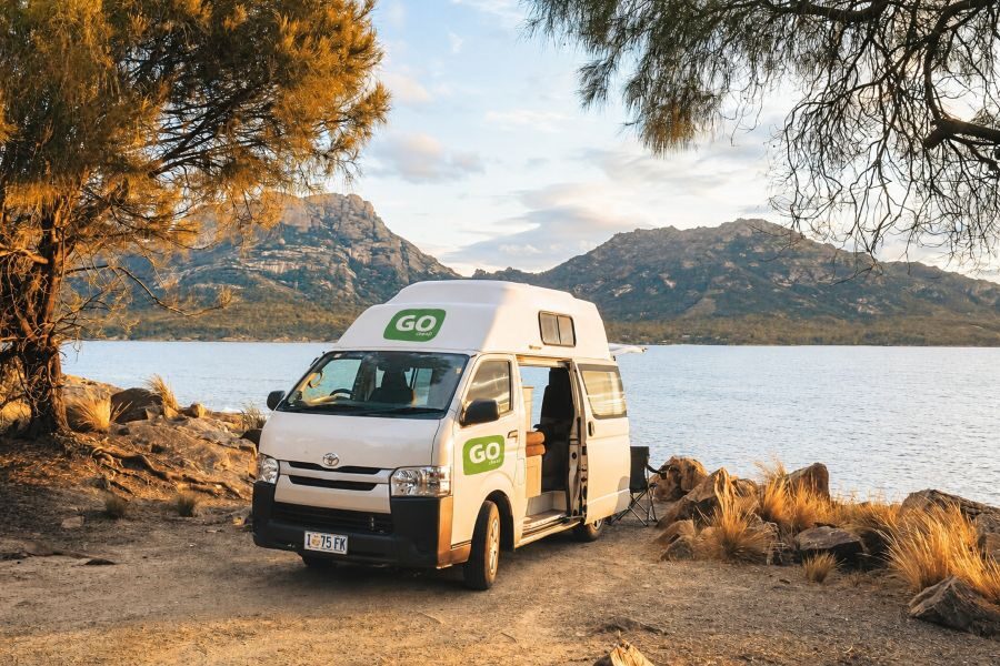 Go Cheap 4 berth Hitop staat geparkeerd aan zee met de zijdeur open