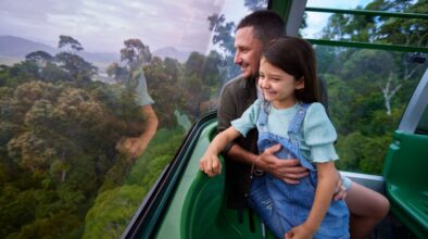 Vader en dochter kijken naar buiten vanuit de Kuranda Skyrail bij Cairns