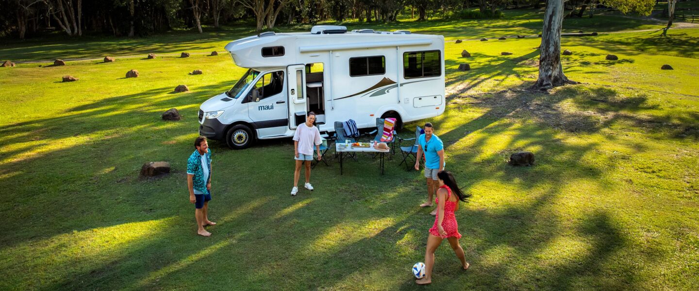 Gezin is aan het voetballen bij de Maui Sunset camper bij Noosa