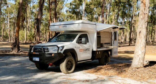 RedSands Wanderer Luxe camper staat geparkeerd in bos met keukenluik open