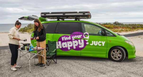 Twee vrouwen maken gebruik van de keuken en tafel van de Jucy Crib Plus aan het strand