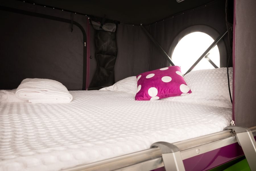 Het bed bovenin de daktent van de Jucy Crib Plus is opgemaakt