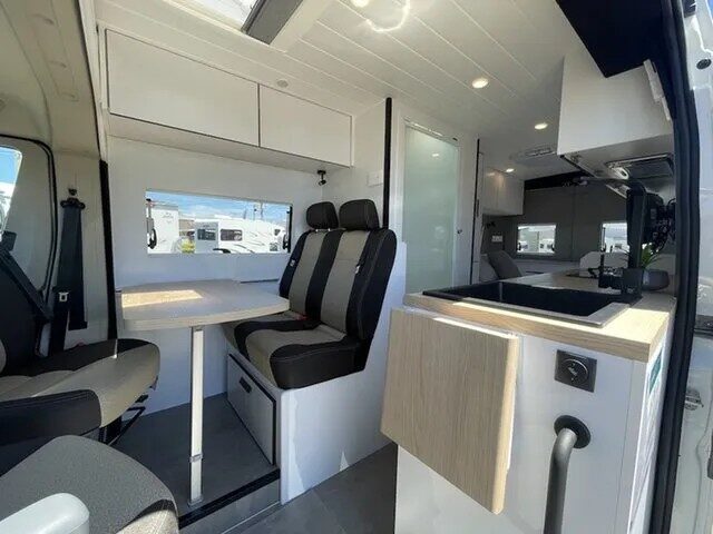 De cabinestoelen van de Star RV Polaris 2 zijn omgedraaid en er zicht op de dinette en keuken