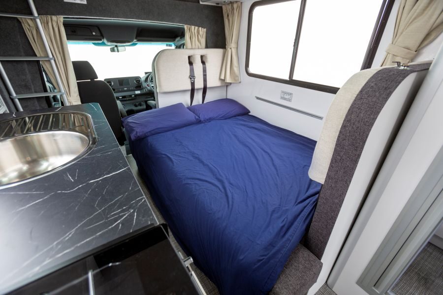 Het bed van de dinette van de Star RV Polaris 6 is opgemaakt