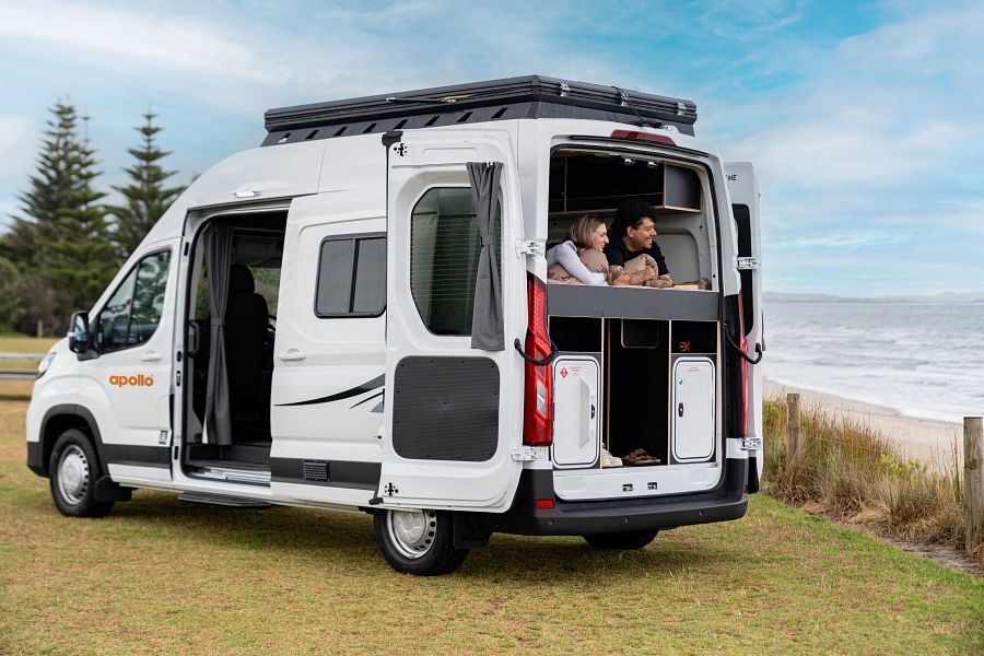 Apollo Endeavour exterieur met ingeklapte pop up roof top tent koppel aan het ontspannen op bed in camper