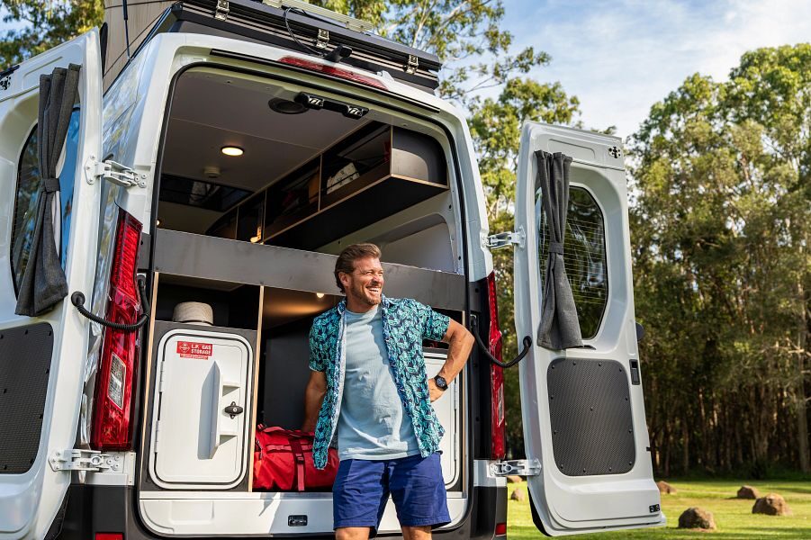 Man staat bij open achterdeuren van de Britz Hitop camper