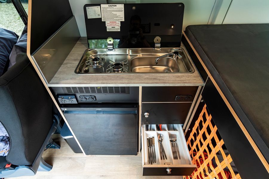 Zicht op de keuken met gasfornuis en lade open in Britz Voyager camper