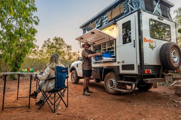 Man kookt en vrouw zit aan tafel bij de Britz Maverick 4WD