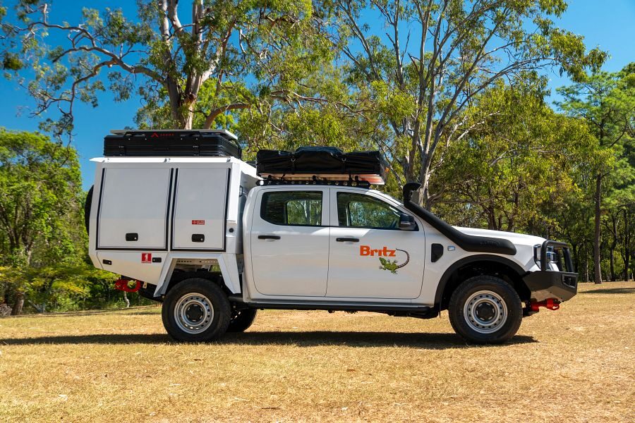 Britz Warrior 4WD staat geparkeerd op het gras met de daktenten dicht