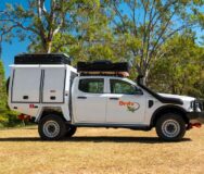 Britz Warrior 4WD staat geparkeerd op het gras met de daktenten dicht