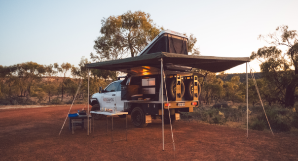 De RedSands 4WD camper is volledig opgesteld in een mooie omgeving met de royale luifel en gereed voor de nacht met de opengeklapte daktent