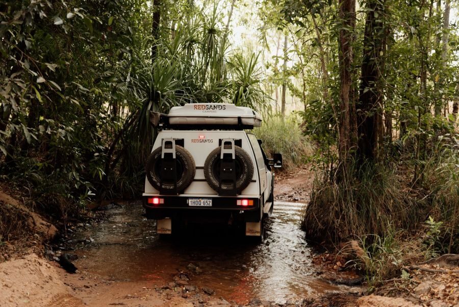 De RedSands tweepersoons 4WD is onderweg, rijdend door een rivierbedding