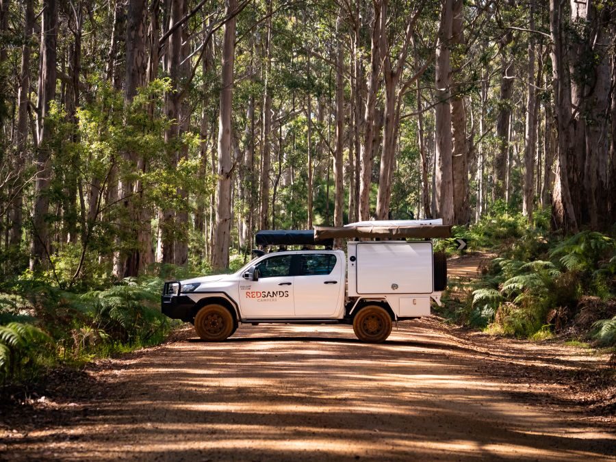 Een tussenstop met de RedSands camper op een landweg tussen de bomen