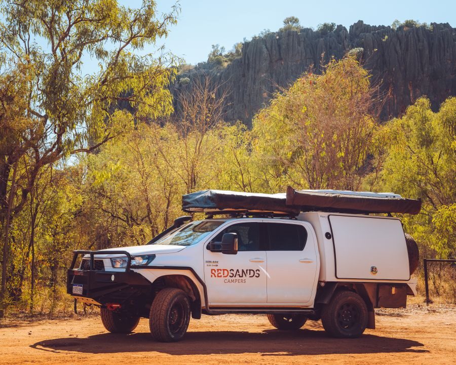 De RedSands 4WD camper maakt een tussenstop op een gravelweg. De twee dichtgeklapte daktenten zijn zichtbaar op deze afbeelding