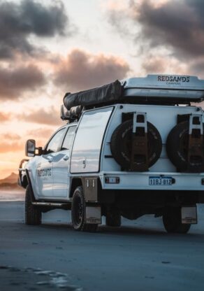 Genietend van het prachtige uitzicht bij zonsondergang bij Cape Le Grand - West Australië - met zicht op de achterzijde van de RedSands camper en reservewielen