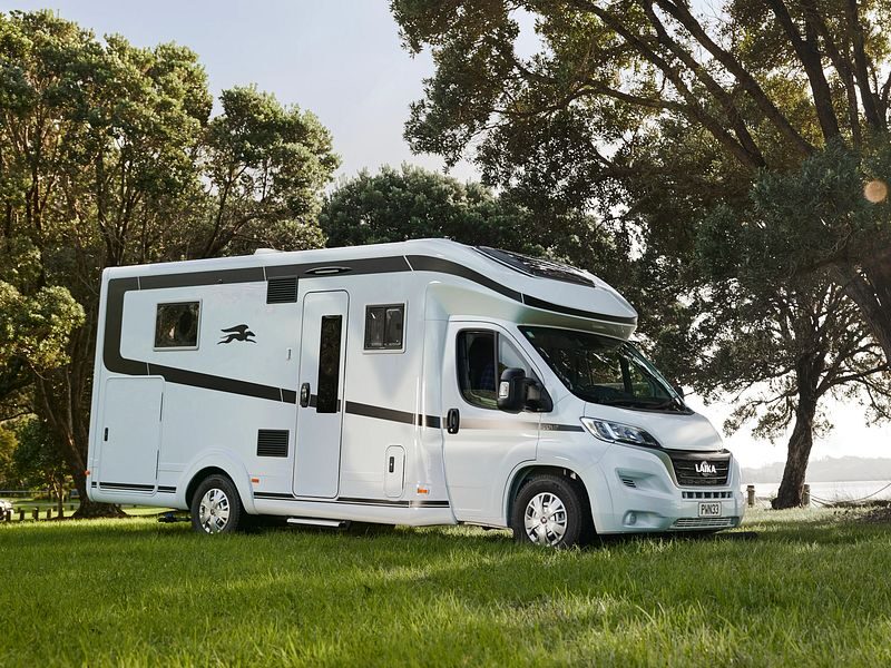 De zijkant van de Britz Wanderer camper geparkeerd op een grasveld in Nieuw-Zeeland