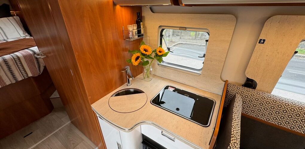 De keuken van de Britz Odyssey camper met wastafel, kooktoestel en oven inclusief raam die je open kunt zetten