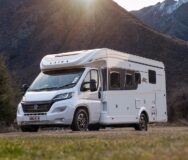 De Britz Odyssey camper geparkeerd op een grasveld tussen de bergen in Nieuw-Zeeland