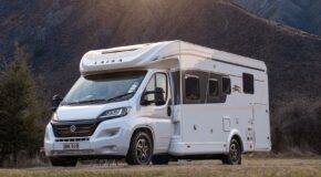 De Britz Odyssey camper geparkeerd op een grasveld tussen de bergen in Nieuw-Zeeland