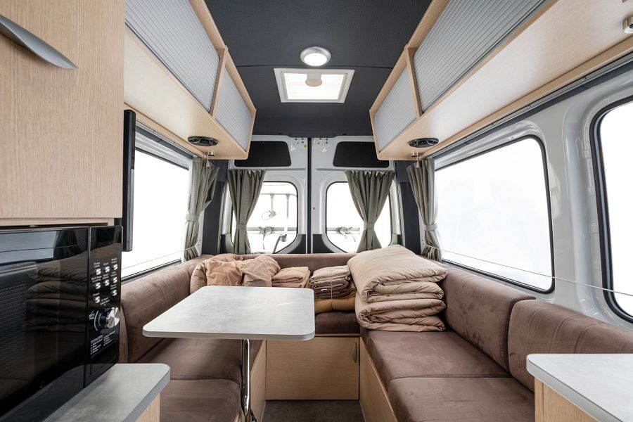 De zithoek aan de achterkant van de Maui Ultima Plus camper met daarboven kastjes om spullen op te bergen
